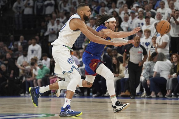 Minnesota Timberwolves center Rudy Gobert, left, and Denver Nuggets forward Aaron Gordon reach for the ball during the second half of Game 6 of an NBA basketball second-round playoff series Thursday,  ...
