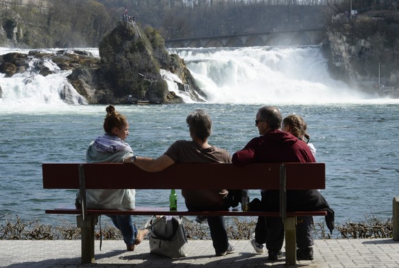 Menschen geniessen bei herrlichem Fruehlingswetter einen Ausflug zum Rheinfall, am Samstag, 29. Maerz 2014, bei Neuhausen. (KEYSTONE/Steffen Schmidt)