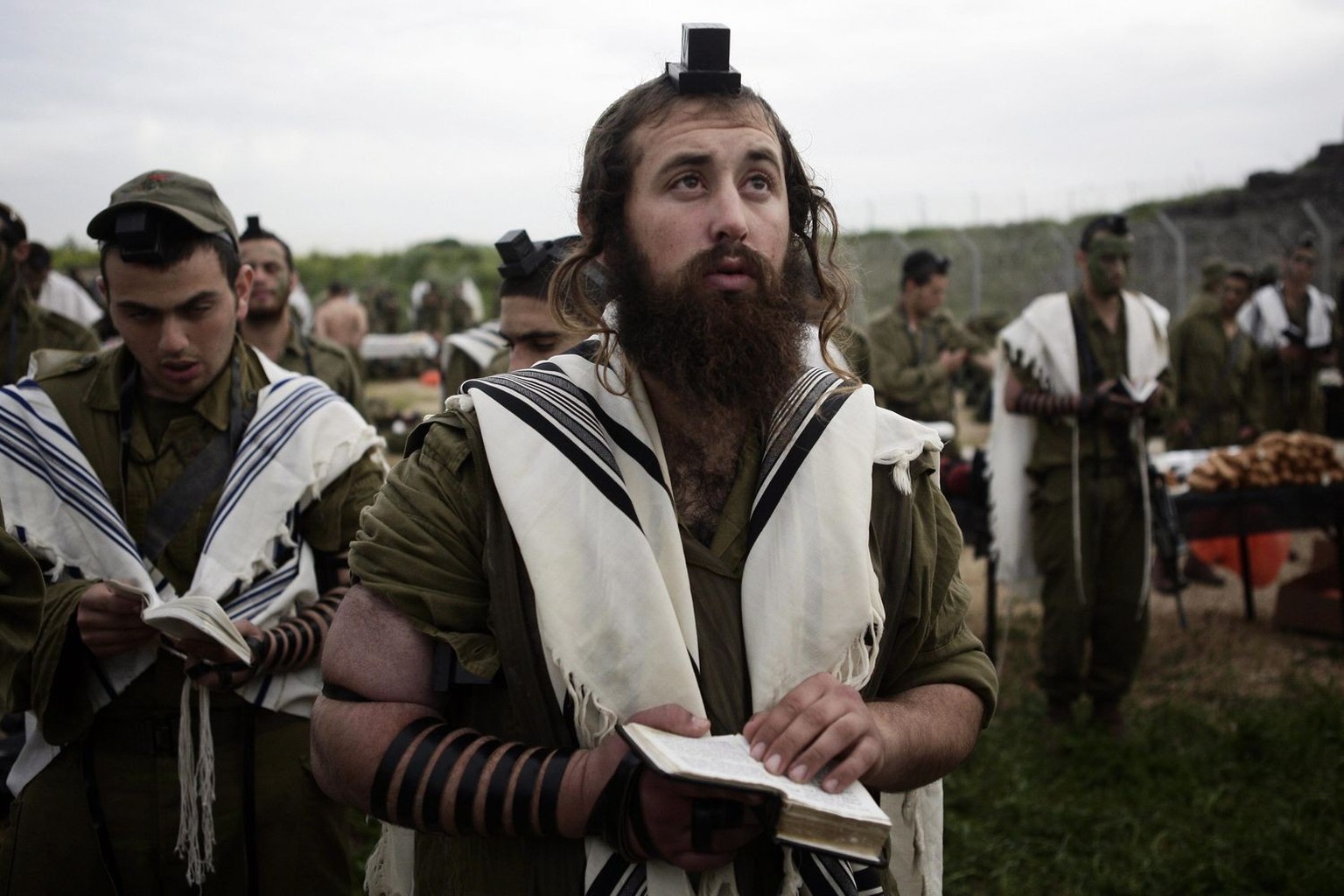 epa02037456 Israeli Soldiers during a morning pray from the Neztah Yehuda Battalion complete the final stages of a 40 kilometer journey, 17 February 2010. The ultra orthodox brigade (Nahal Haredi) was ...