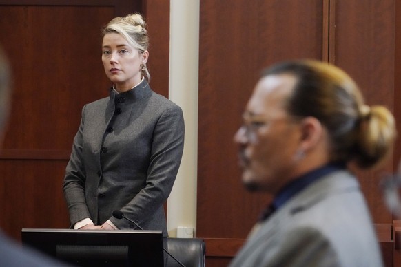 epa09951241 Actress Amber Heard and Actor Johnny Depp watch as the jury leave the courtroom for a lunch break at the Fairfax County Circuit Courthouse in Fairfax, Virginia, USA, 16 May 2022. Johnny De ...