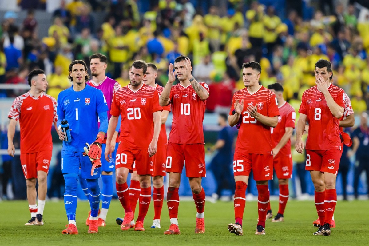 Switzerland's soccer players with midfielder Granit Xhaka, center, react during the FIFA World Cup Qatar 2022 group G soccer match between Brazil and Switzerland at the Stadium 974, in Doha, Qata ...