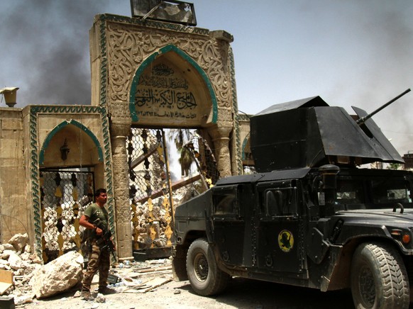 epaselect epa06064341 An Iraqi soldier stands next to the destroyed Great Mosque of al-Nuri in the old city area western Mosul, Iraq, 03 July 2017. Iraqi security forces are in the final stages of the ...