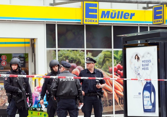 epa06114871 Police officers stands in front of a supermarket in Hamburg, Germany, 27 July 2017. According to police reports a man attacked several people in a supermarket in Hamburg. One victim is rep ...