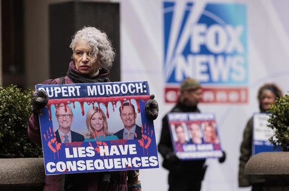 epa10495778 Sandy R., of New York, holds a sign while participating in a protest organized by the group Rise and Resist outside of Fox News headquarters in New York, New York, USA, 28 February 2023. A ...