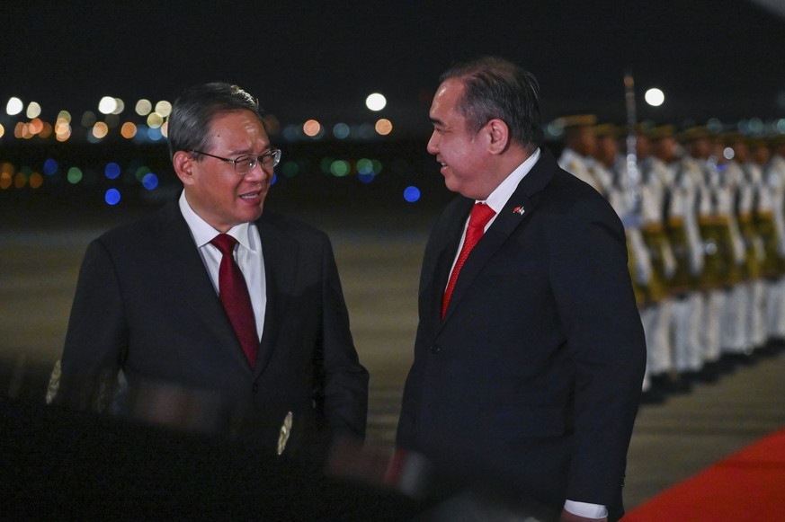 In this photo released by Malaysia&#039;s Department of Information, China&#039;s Premier Li Qiang, left, is greeted by Malaysia&#039;s Minster of Transport, Anthony Loke, as he arrives at Sepang Inte ...