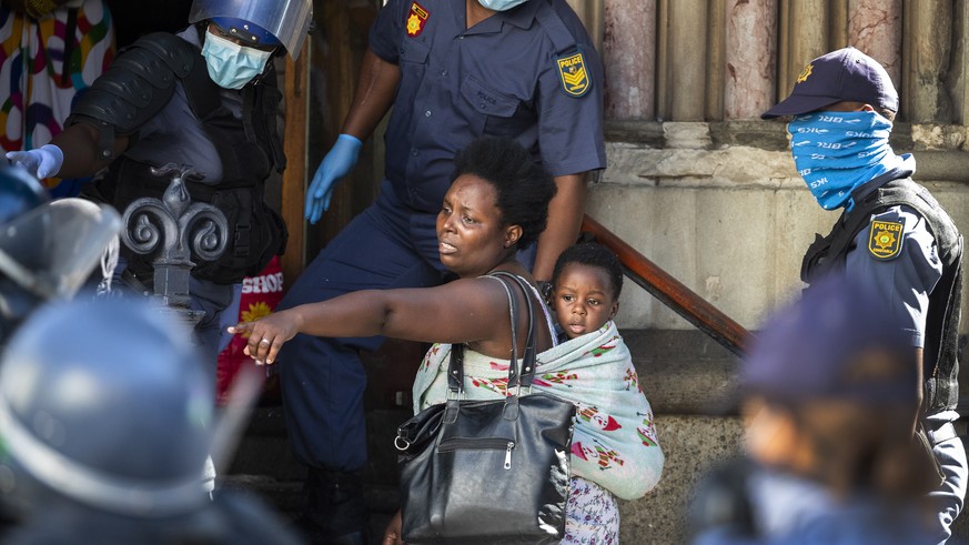 epaselect epa08339209 A mother and child, part of a group of African foreign nationals from various African countries, are moved by South African police out of the Central Methodist Church where they ...