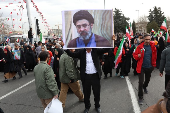 epa12726146 An Iranian man holds a picture of Mojtaba Khamenei, the son of the Iranian Supreme Leader, as he takes part in celebrations of the 47th anniversary of the Islamic Revolution in Tehran, Ira ...