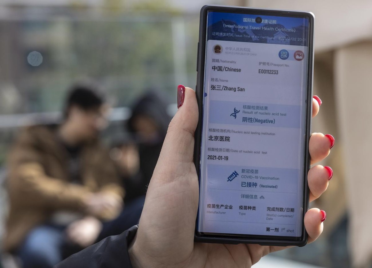 epa09064822 A woman showcases the new China's international travel health certificate application example for smartphones in Shanghai, China, 10 March 2021. The official launch of the Chinese ver ...