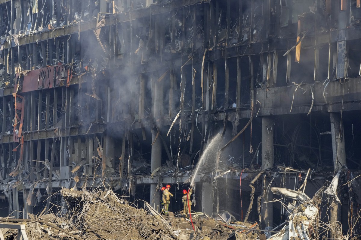 Ukrainian firefighters extinguish smoke after shelling of a shopping center, in Kyiv, Ukraine, Monday, March 21, 2022. Eight people were killed in the attack. (AP Photo/ (AP Photo/Efrem Lukatsky)