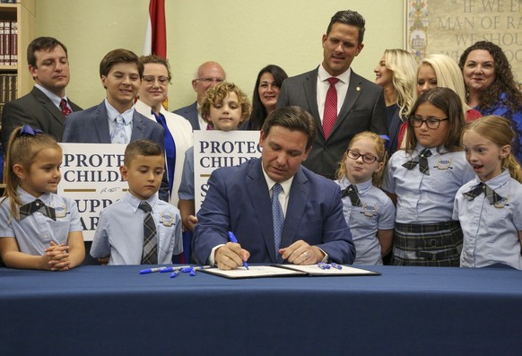 Florida Gov. Ron DeSantis signs the Parental Rights in Education bill at Classical Preparatory school, March 28, 2022 in Shady Hills, Fla. Hundreds of students at a central Florida high school were to ...