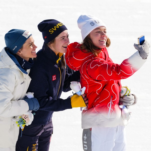 Gold medalist Ebba Andersson, of Sweden, poses on the podium flanked by silver medalist Heidi Weng, of Norway, left, and bronze medalist Nadja Kaelin, of Switzerland, after the cross country skiing wo ...
