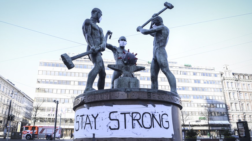 epa08334291 A banner at the Three Smiths Statue reads 'Stay Strong' in Helsinki, Finland, 31 March 2020. According to the Johns Hopkins University, Finland has registered at least 1,418 COVI ...