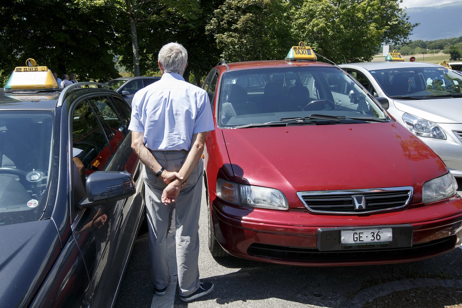 Les chauffeurs de taxis genevois attendent le depart de leur defile contre Uber dans les rues genevoises, ce mardi 28 juin 2016 a Geneve. A Geneve, une centaine de taxis ont defile contre Uber mardi a ...