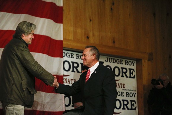 Steve Bannon, left, introduces U.S. senatorial candidate Roy Moore, right, during a campaign rally, Tuesday, Dec. 5, 2017, in Fairhope, Ala. (AP Photo/Brynn Anderson)