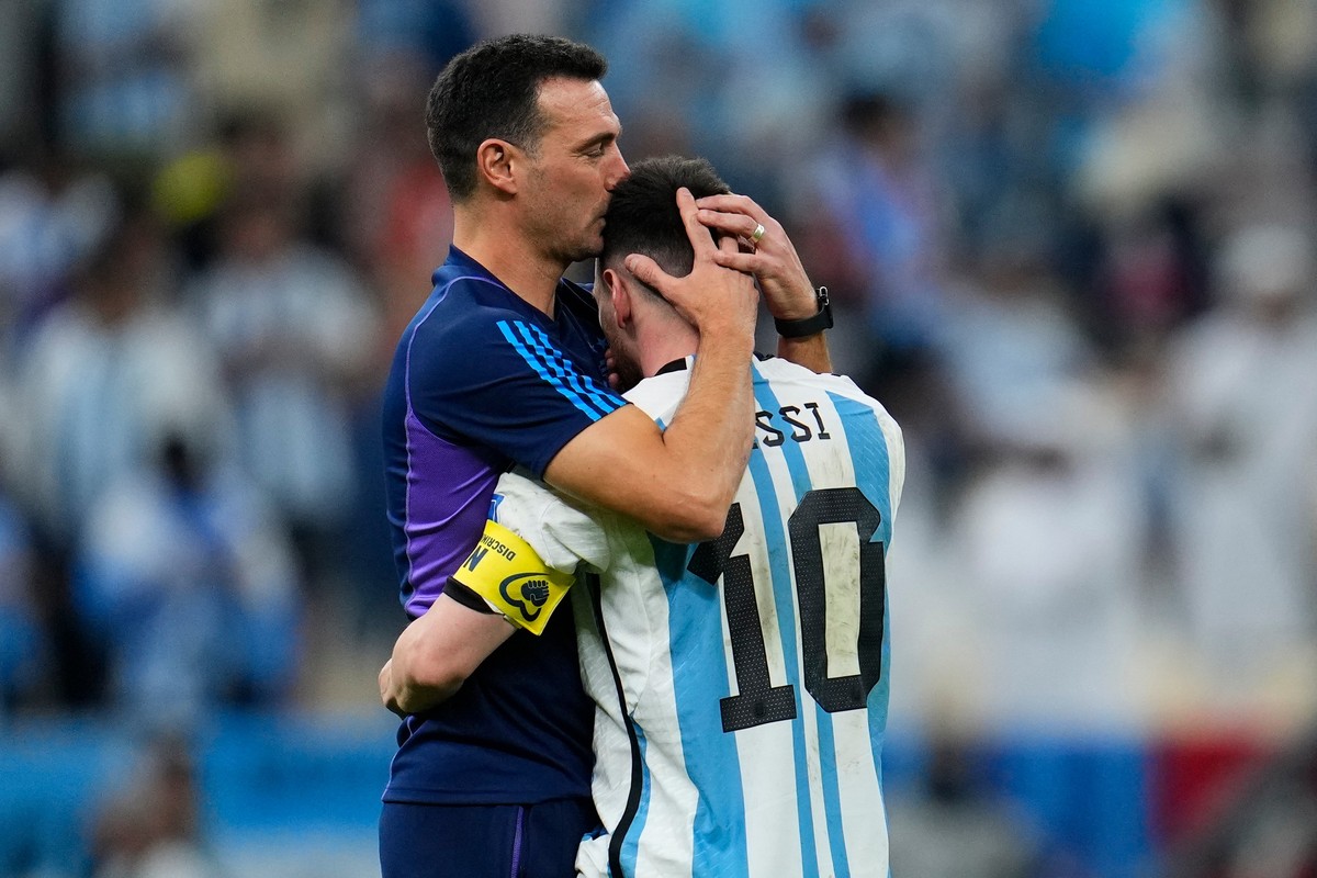 FILE - Argentina's head coach Lionel Scaloni kisses Argentina's Lionel Messi, right, at the end of the World Cup quarterfinal soccer match between the Netherlands and Argentina, at the Lusai ...