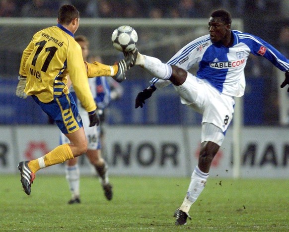 Der GC Spieler Papa Bouba Diop, rechts im Zweikampf mit Zuerichs Feliciano Magro am Sonntag, 25. November 2001, waehrend des NLA Meisterschaftsspiels GC - FCZ. (KEYSTONE/Michele Limina)