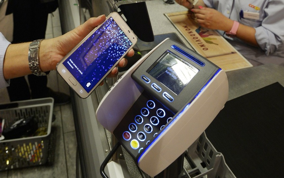Eine Frau bezahlt mit dem Smartphone an der Kasse einer Coop Filiale in Zuerich am Dienstag, 1. Juli 2014. Mit "Tapit" kommt erstmals eine Smartphone App auf den Schweizer Markt, die das Bez ...
