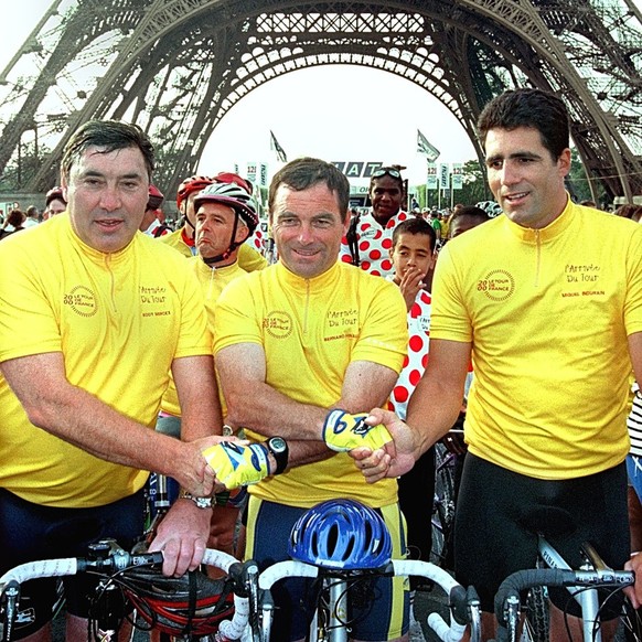 Five-time Tour de France cycling race winners Eddie Meckx of Belgium, Bernard Hinault of France and Miguel Indurain of Spain (left to right) shake hands before a ride with thousands of amateur cyclist ...