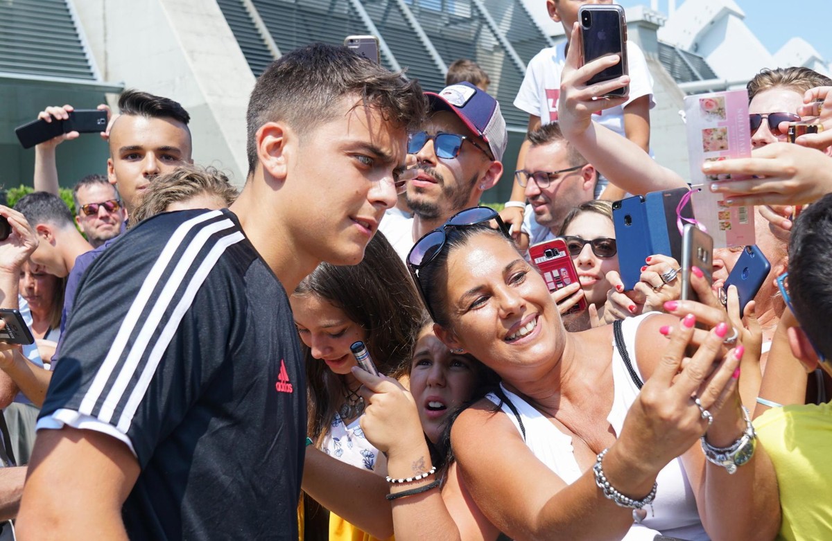 epa07757783 Juventus' Argentinian forward Paulo Dybala leaves J Medical Center and signs autographs for Juventus supporters in Turin, Italy,, 05 August 2019. Manchester United ended their interes ...