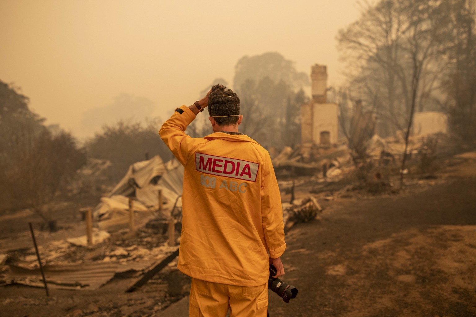 epaselect epa08097374 ABC photographer Matt Roberts reacts to seeing his sister's house destroyed by a bushfire in Quaama, New South Wales, Australia, 01 January 2020. EPA/SEAN DAVEY AUSTRALIA AN ...