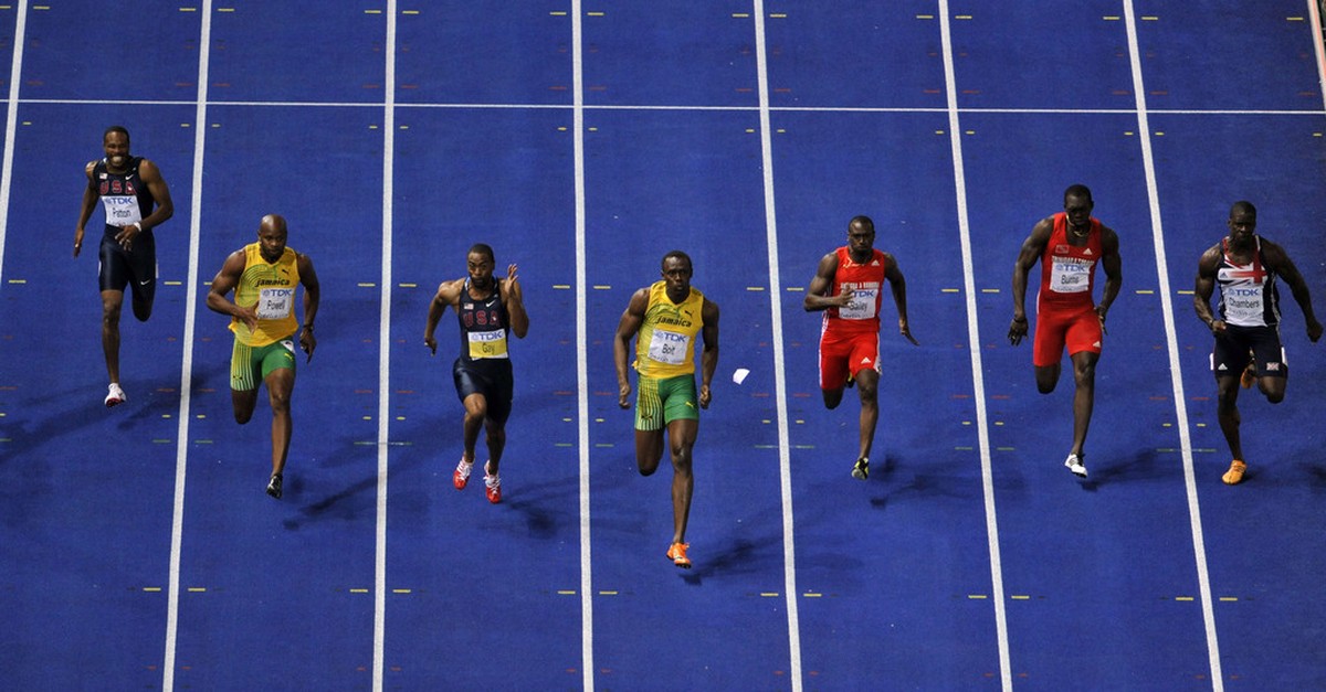 Jamaica's Usain Bolt, center, runs to setting a new Men's 100m World Record during the World Athletics Championships in Berlin on Sunday, Aug. 16, 2009. (AP Photo/Gero Breloer)