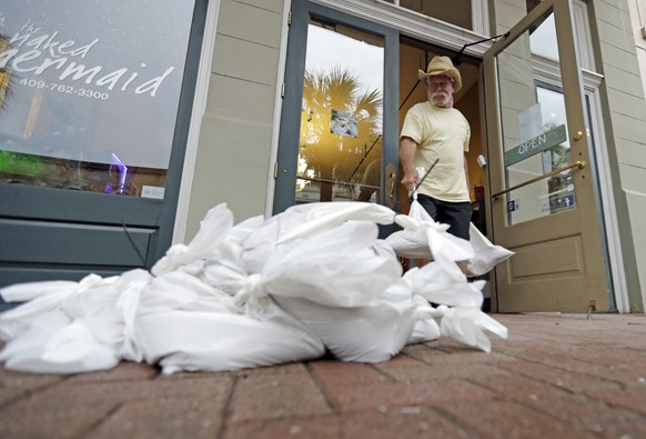Lynn Dixon places sandbags outside their home decor store in Galveston, Texas as Hurricane Harvey intensifies in the Gulf of Mexico Friday, Aug. 25, 2017. Conditions were deteriorating along Texas ...