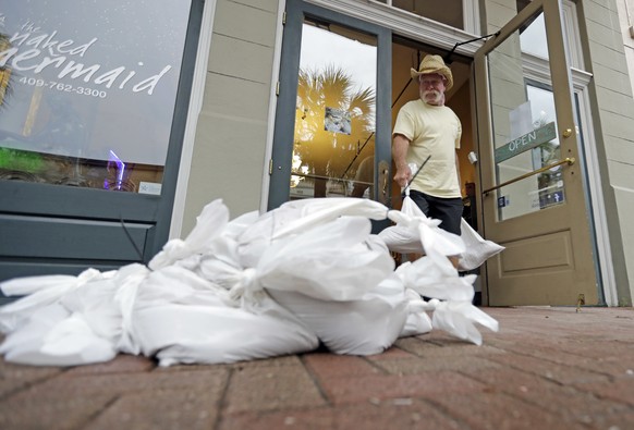 Lynn Dixon places sandbags outside their home decor store in Galveston, Texas as Hurricane Harvey intensifies in the Gulf of Mexico Friday, Aug. 25, 2017. Conditions were deteriorating along Texas&#03 ...
