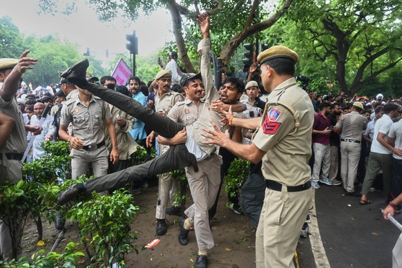 Police detains a supporter of the Cockroach Janta Party while he with others attempt to march toward India's Parliament, demanding the resignation of the education minister, in New Delhi, Monday, ...