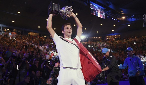 Switzerland's Roger Federer holds his trophy aloft after defeating Croatia's Marin Cilic in the men's singles final at the Australian Open tennis championships in Melbourne, Australia, ...