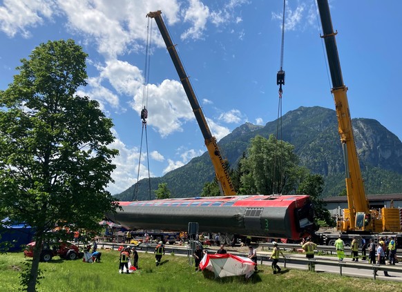 04.06.2022, Bayern, Garmisch-Partenkirchen: Die Rettungskr�fte haben nach einem schweren Zugungl�ck einen der Waggons angehoben und legen ihn auf die Stra�e. Bei dem Ungl�ck sind mindestens vier Mensc ...