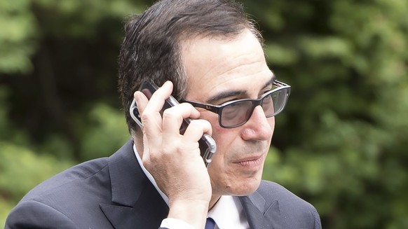 U.S. Treasury Secretary Steven Mnuchin talks on his phone before a meeting of the G7 Finance and Central Bank Governors in Whistler, B.C., Friday, June, 1, 2018. (Jonathan Hayward/The Canadian Press v ...