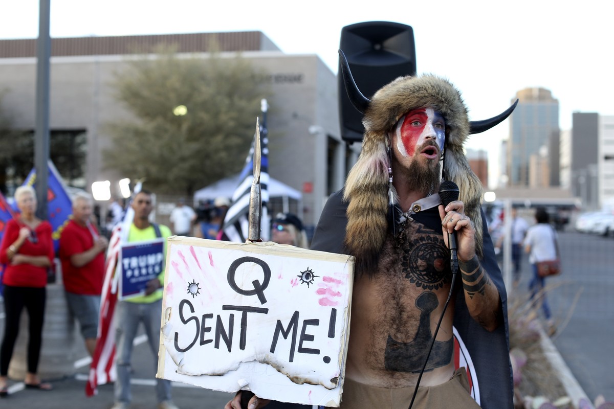A Qanon believer speaks to a crowd of President Donald Trump supporters outside of the Maricopa County Recorder's Office where votes in the general election are being counted, in Phoenix, Thursda ...