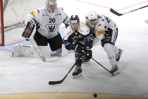 From left Fribourg&#039;s goalkeeper Reto Berra, Ambri&#039;s player Johnny Kneubuehler and Fribourg&#039;s player Sandro Schmid, during the match of National League Swiss Championship 2021/22 between ...