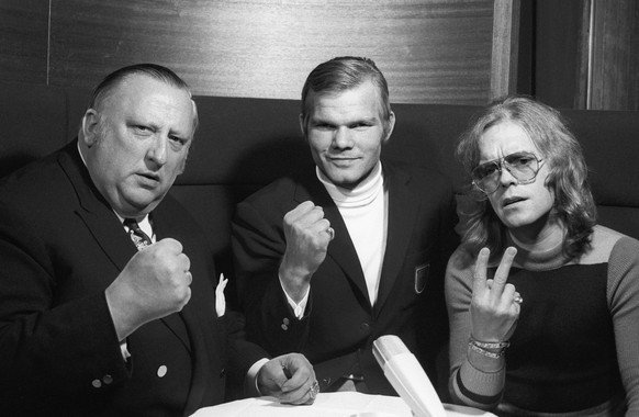 Der deutsche Boxer Juergen Blin, Mitte, posiert im Dezember 1971 in Zuerich vor seinem Kampf gegen Muhammed Ali mit seinem Manager Fritz Wiene, links und Veranstalter Hansruedi Jaggi, rechts. Blin box ...