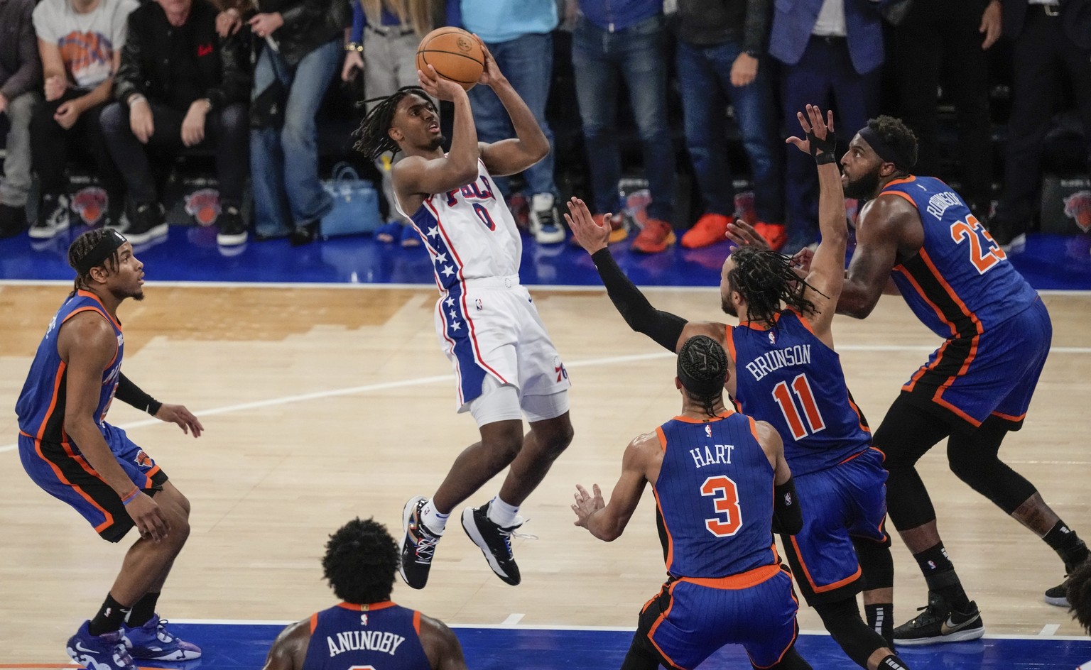 Philadelphia 76ers&#039; Tyrese Maxey (0) shoots over New York Knicks&#039; Jalen Brunson (11), Mitchell Robinson (23) and Josh Hart (3) during the second half of Game 5 in an NBA basketball first-rou ...