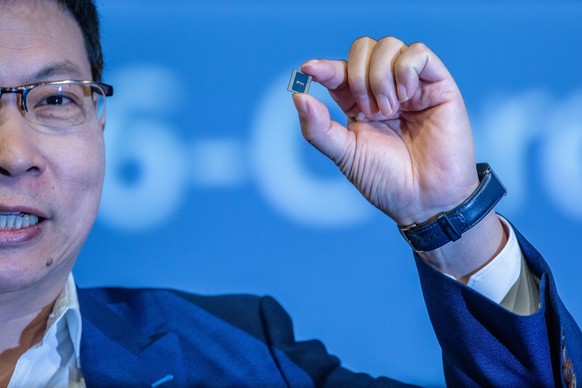 epa07822075 Keynote speaker Richard Yu CEO of HUAWEI holds the new HUAWEI Kirin 990 5G processor during a speech at the opening press conference of the Internationale Funkaustellung Berlin (IFA), an i ...