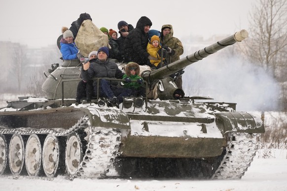 People ride with their children atop a Soviet T-54 tank during a military historical festival in the family historical tank park outside St. Petersburg, Russia, Saturday, Feb. 4, 2023. (AP Photo/Dmitr ...