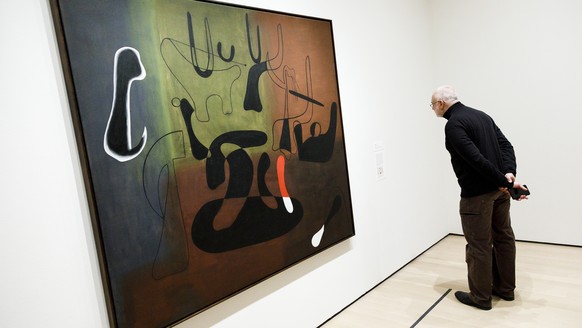 epa07383676 A man looks at a painting entitled 'Painting' by Spanish artist Joan Miro at the exhibit 'Joan Miro: Birth of the World' during a preview at the Museum of Modern Art in New York, New York, USA, 20 February 2019. The exhibit runs from 24 February until 15 June 2019 and features 60 works by Miro from the MoMA's collection and works on loan to the museum.  EPA/JUSTIN LANE