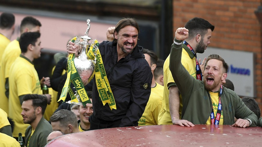 Norwich City manager Daniel Farke displays the trophy during a promotion parade, in Norwich City Centre, in Norwich, England, Monday May 6, 2019. Having already secured promotion to the Premier League ...