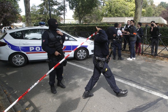 French hooded police officers cordon off the area after a knife attack Thursday, Aug. 23, 2018 in Trappes, west of Paris. A man flagged by French authorities as a suspected radical killed his mother a ...