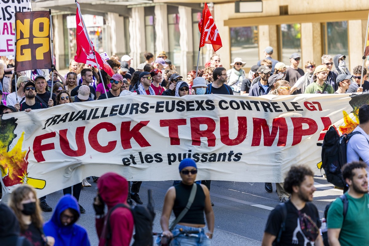 Des manifestants avec des pancartes et des drapeaux defilent dans les rues de Geneve, lors du defile du 1er mai - Fete du Travail, ce vendredi 1 mai 2026 a Geneve. Plusieurs milliers de personnes ont  ...