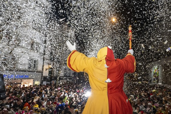 Ein Narr geniesst den Foetzeliraege nach dem Urknall auf dem Kapellplatz an der Fritschi-Tagwache der Luzerner Fasnacht am Schmutzigen Donnerstag, 12. Februar 2026 in Luzern. Die Luzerner Fasnacht dau ...