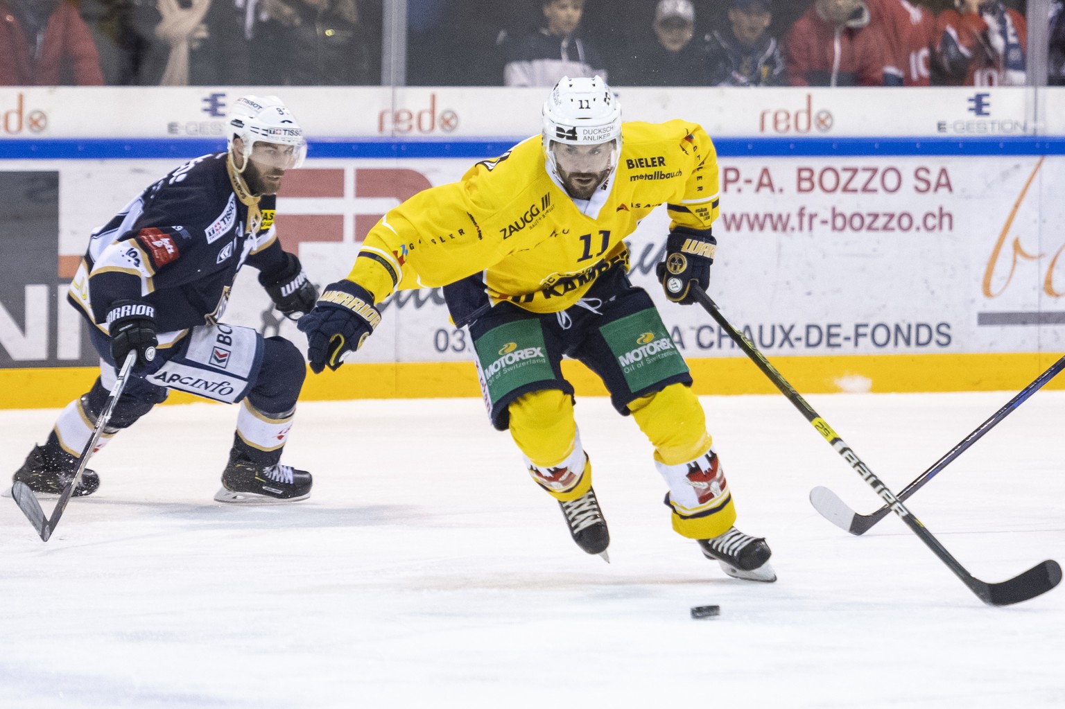 Le joueur neuchatelois Jerome Bonnet gauche, lutte pour le puck avec le joueur bernois Hans Pienitz, droite, lors du 1er match de la finale de playoff du championnat suisse de hockey sur glace, Swiss  ...