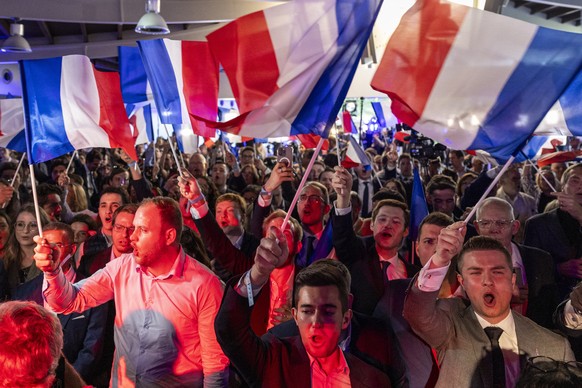 epa11400658 Supporters wave flags at the electoral party of the French right-wing party National Rally (Rassemblement National or RN) in Paris, France, 09 June 2024, after the first results of Europea ...