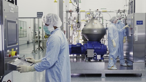 In this undated image from video provided by Regeneron Pharmaceuticals on Friday, Oct. 2, 2020, scientists work with a bioreactor at a company facility in New York state, for efforts on an experimenta ...