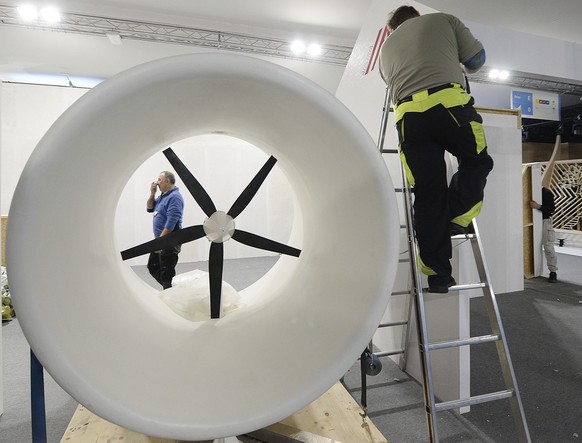 A worker dismantles the exhibition pavilion of Austria as the U.N. Climate conference draws to a close, as negotiators from almost 200 countries continue haggling over the fine print of the Paris clim ...