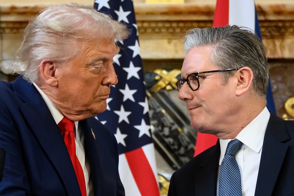 U.S. President Donald Trump, left, and British Prime Minister Keir Starmer look at each other as they shake hands during a press conference at Chequers near Aylesbury, England, Thursday Sept. 18, 2025 ...