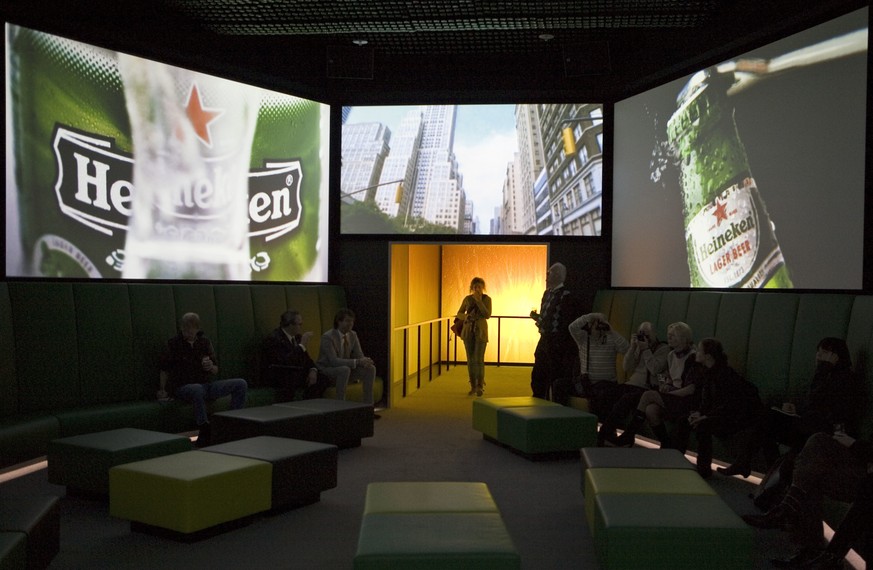 FILE- In this Dec. 9, 2008, file photo, visitors watch Heineken commercials on large screens at the Heineken Experience, Amsterdam. Heineken has removed a commercial for its light beer after some comp ...