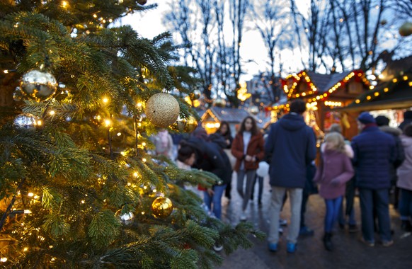 Visitors gather around market booths during the Christmas market &quot;Noel aux Bastions&quot; in the Parc des Bastions, in Geneva, Switzerland, Sunday, December 22, 2019. (KEYSTONE/Salvatore Di Nolfi ...