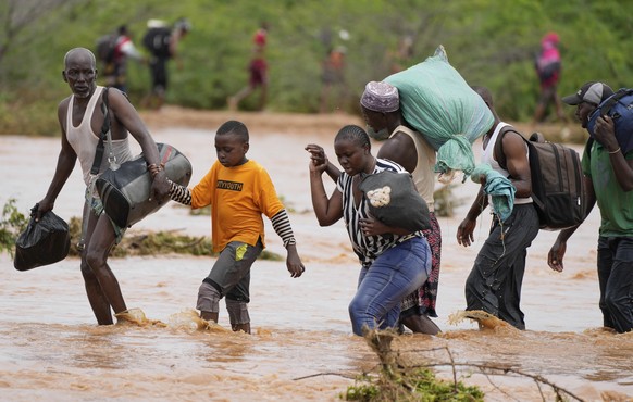 Residents cross a road damaged by El Ni�o rains in Tula, Tana River county in Kenya on Saturday, Nov. 25, 2023. Severe flooding in the country has killed at least 71 people and displaced thousands, ac ...